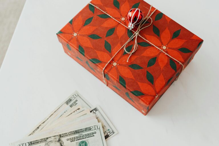 red gift box and money representing affordable Christmas gifts